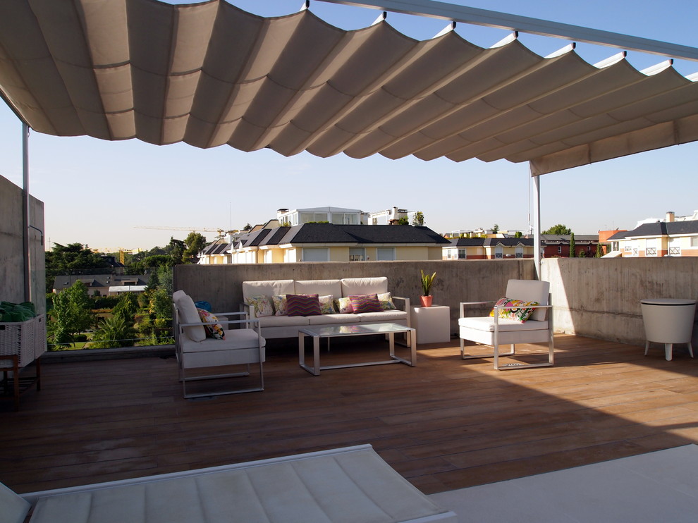 Mid-sized modern rooftop deck in Madrid with an awning.