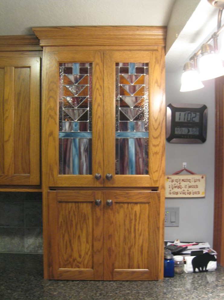 Example of a mid-sized classic u-shaped ceramic tile and gray floor enclosed kitchen design with a double-bowl sink, shaker cabinets, dark wood cabinets, granite countertops, gray backsplash, stone tile backsplash, black appliances and a peninsula
