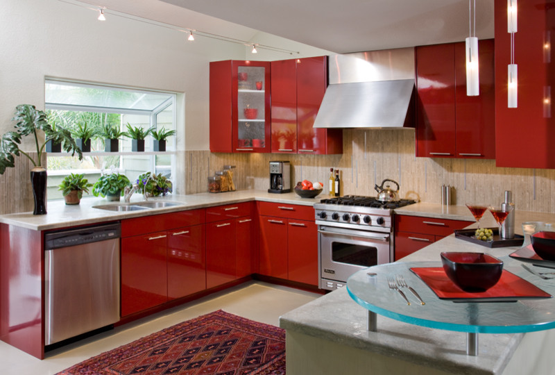 Design ideas for a mid-sized contemporary u-shaped kitchen pantry in San Diego with an undermount sink, flat-panel cabinets, red cabinets, limestone benchtops, grey splashback, stone tile splashback, stainless steel appliances and no island.