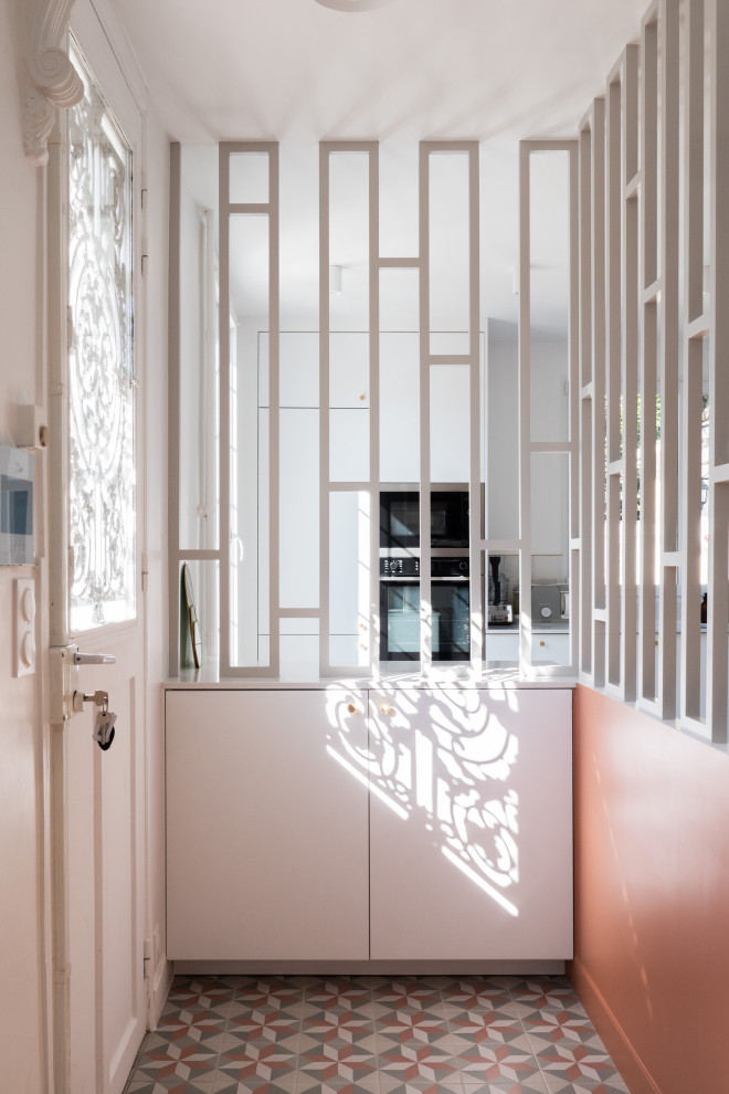 Kleiner Moderner Eingang mit Keramikboden, Einzeltür, weißer Haustür und buntem Boden in Paris