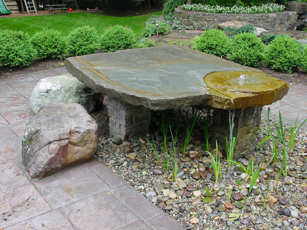Photo of a mid-sized transitional backyard water fountain landscape in DC Metro.