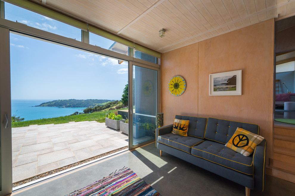 Photo of a mid-sized contemporary open concept living room in Auckland with concrete floors.