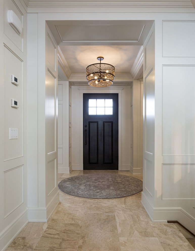 Inspiration for a mid-sized traditional foyer in Calgary with white walls, travertine floors, a single front door and a dark wood front door.