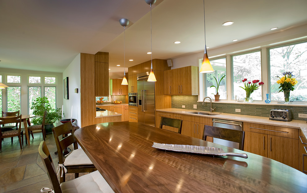 Mid-sized transitional galley concrete floor open concept kitchen photo in DC Metro with an undermount sink, flat-panel cabinets, green backsplash, stainless steel appliances, quartz countertops and glass tile backsplash