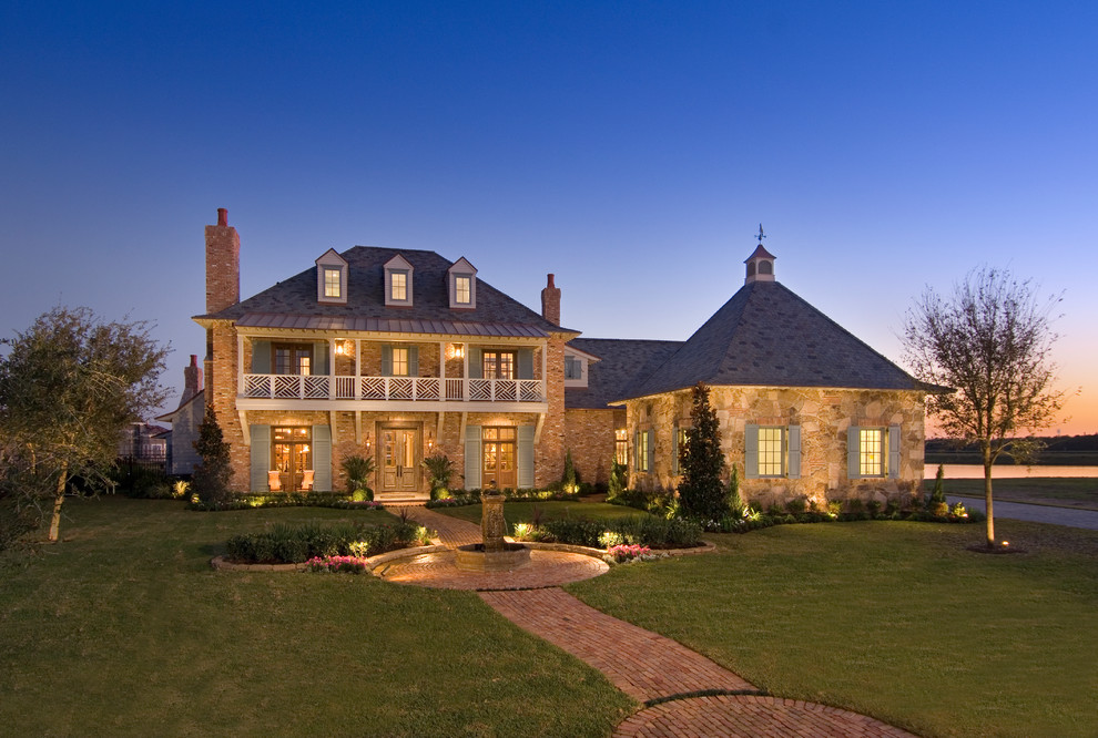 This is an example of a large traditional three-storey house exterior in Houston with stone veneer.