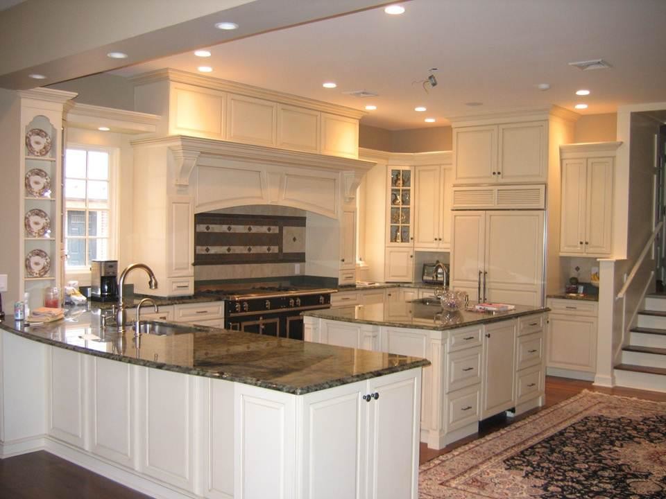 Inspiration for a mid-sized traditional u-shaped kitchen in Philadelphia with an undermount sink, raised-panel cabinets, white cabinets, granite benchtops, beige splashback, ceramic splashback, panelled appliances, dark hardwood floors and with island.