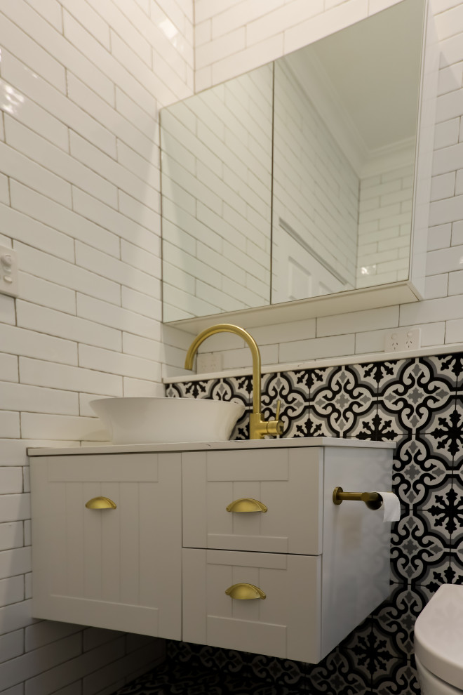 Inspiration for a small eclectic master bathroom in Sydney with beaded inset cabinets, white cabinets, a freestanding tub, an open shower, a one-piece toilet, white tile, subway tile, white walls, cement tiles, a vessel sink, engineered quartz benchtops, black floor, an open shower, white benchtops, an enclosed toilet, a single vanity, a floating vanity, coffered and brick walls.