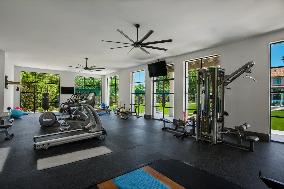Inspiration for a mediterranean multipurpose gym in Dallas with white walls and black floor.