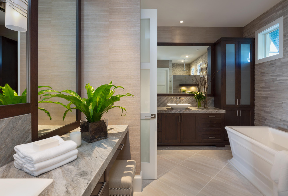 This is an example of a large asian master bathroom in Miami with shaker cabinets, dark wood cabinets, a freestanding tub, brown tile, matchstick tile, beige walls, porcelain floors, a vessel sink, granite benchtops, beige floor and grey benchtops.