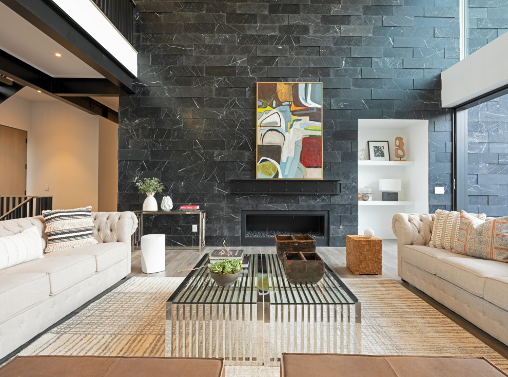 Inspiration for a large modern open concept living room in Denver with white walls, medium hardwood floors, a standard fireplace and a stone fireplace surround.