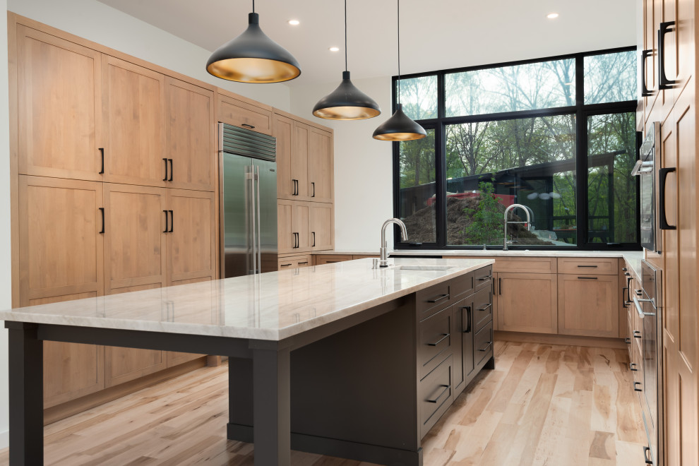 Mid-sized transitional u-shaped light wood floor eat-in kitchen photo with an undermount sink, shaker cabinets, light wood cabinets, quartzite countertops, stainless steel appliances, an island and white countertops