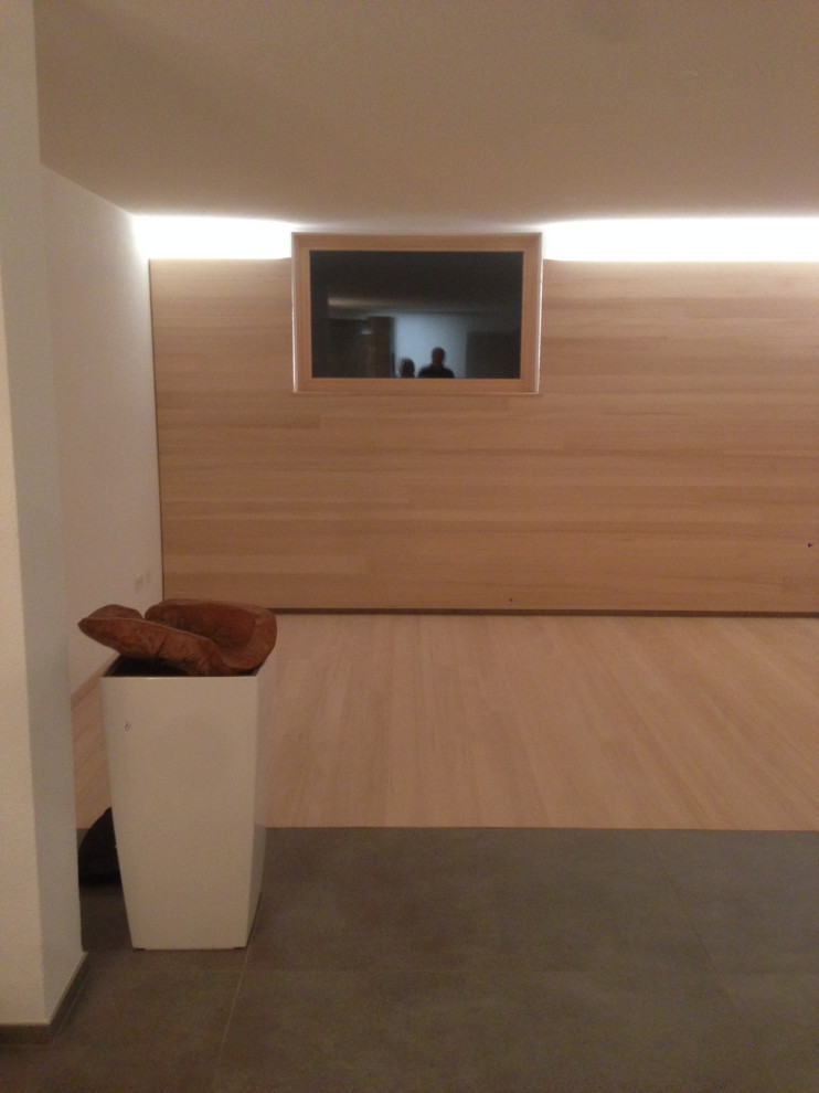 Multifunktionaler, Großer Moderner Fitnessraum mit weißer Wandfarbe, hellem Holzboden und grauem Boden in Stuttgart