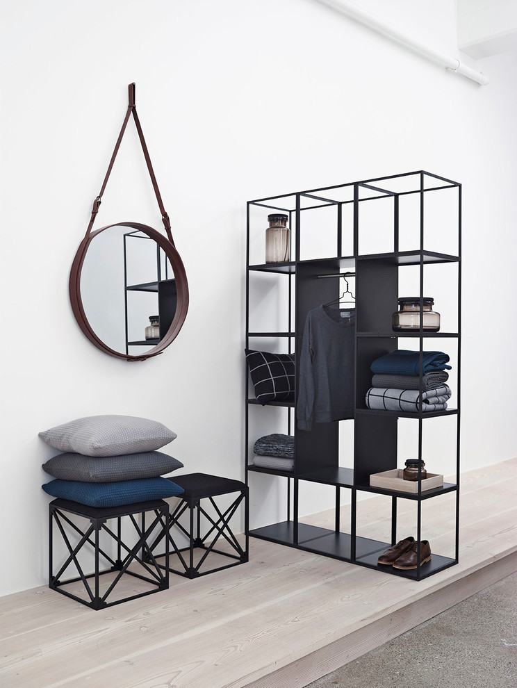 Inspiration for a mid-sized scandinavian men's storage and wardrobe in Hamburg with open cabinets, black cabinets, light hardwood floors and beige floor.