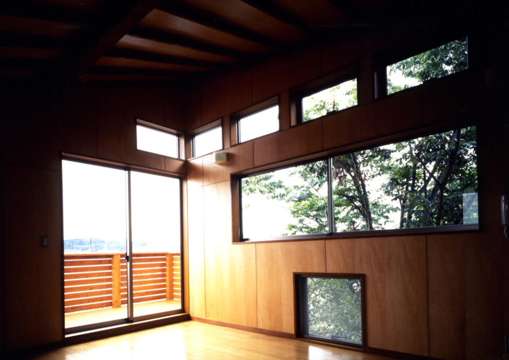 Mittelgroßes Modernes Nähzimmer ohne Kamin mit brauner Wandfarbe, hellem Holzboden, freistehendem Schreibtisch, grünem Boden, freigelegten Dachbalken und Holzdielenwänden in Sonstige