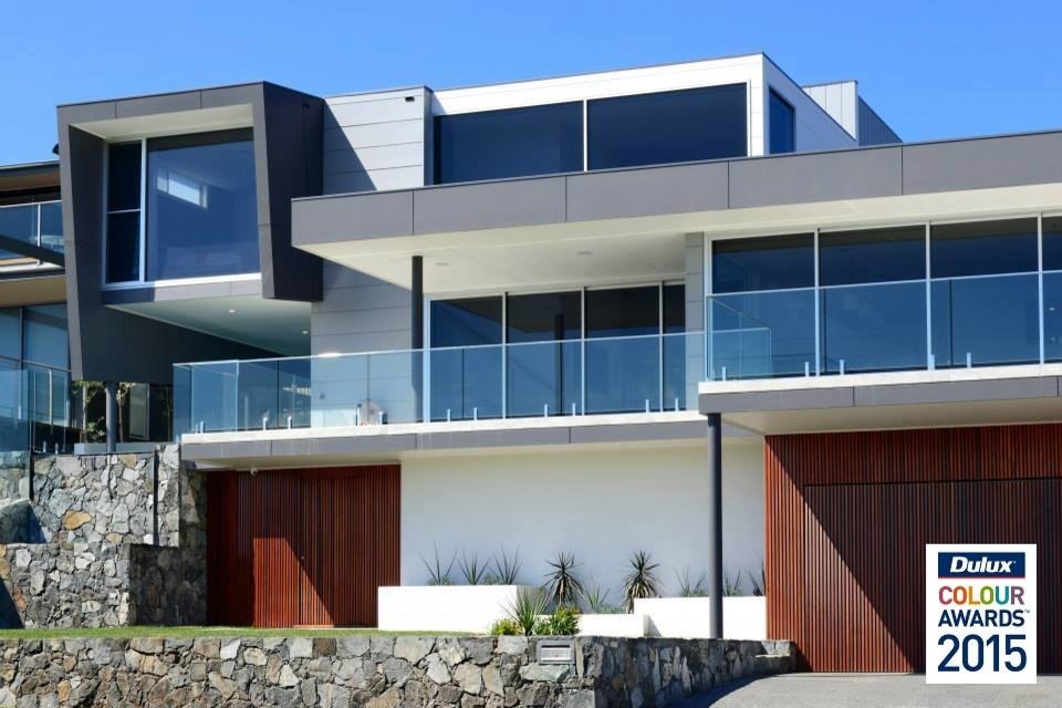 This is an example of a mid-sized modern two-storey white exterior in Wollongong with mixed siding and a flat roof.