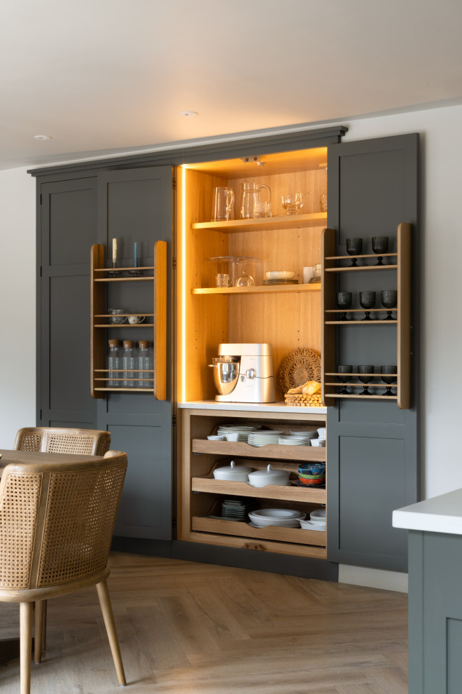 Design ideas for a medium sized classic single-wall kitchen/diner in London with a submerged sink, shaker cabinets, quartz worktops, white splashback, engineered quartz splashback, integrated appliances, medium hardwood flooring, an island and white worktops.
