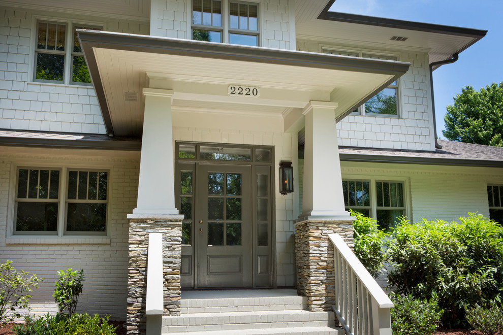 Inspiration for a large traditional two-storey beige exterior in Charlotte with stone veneer and a gable roof.