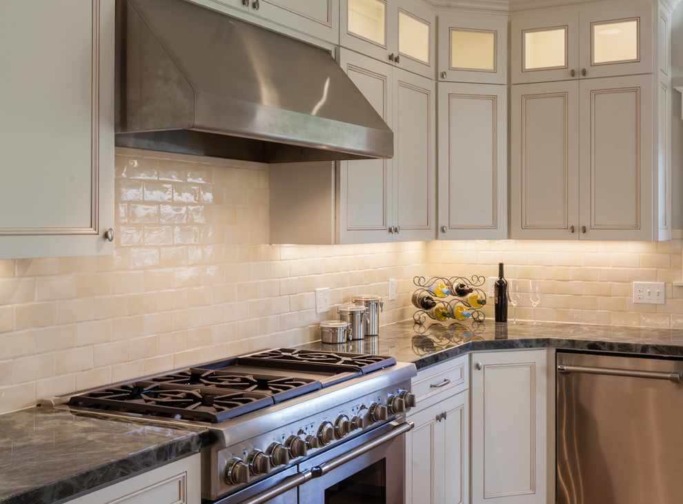 Photo of an arts and crafts u-shaped kitchen in San Francisco with white cabinets, subway tile splashback, stainless steel appliances and recessed-panel cabinets.