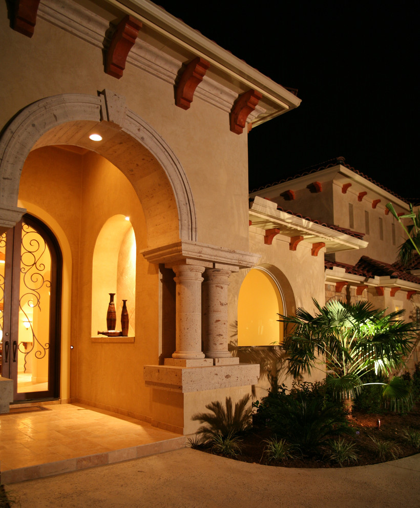 This is an example of a large mediterranean front door in Austin with beige walls, travertine floors, a double front door and a glass front door.