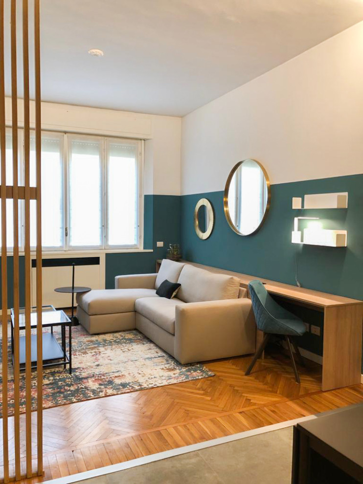 Ispirazione per un soggiorno minimal di medie dimensioni e chiuso con pareti verdi, parquet scuro, pavimento marrone e pannellatura