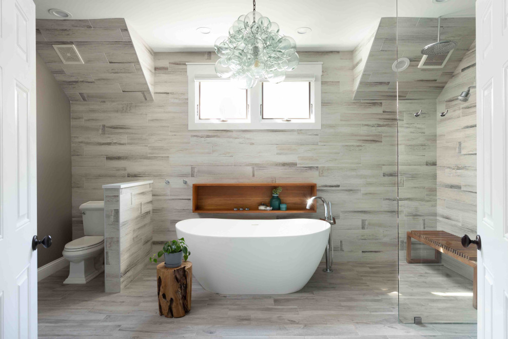 Inspiration for a mid-sized contemporary master bathroom in Chicago with grey cabinets, a freestanding tub, a curbless shower, a two-piece toilet, multi-coloured tile, porcelain tile, beige walls, porcelain floors, a drop-in sink, engineered quartz benchtops, beige floor, an open shower, beige benchtops, a shower seat and a double vanity.
