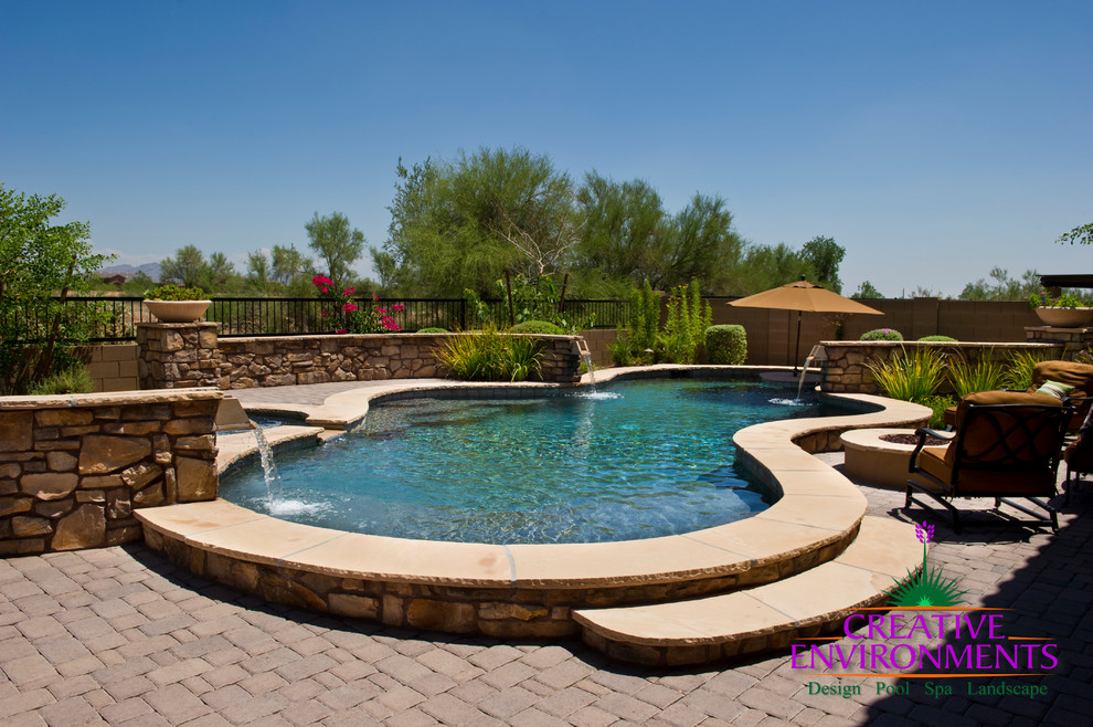 Home design - huge modern backyard stamped concrete and custom-shaped infinity home design idea in Phoenix