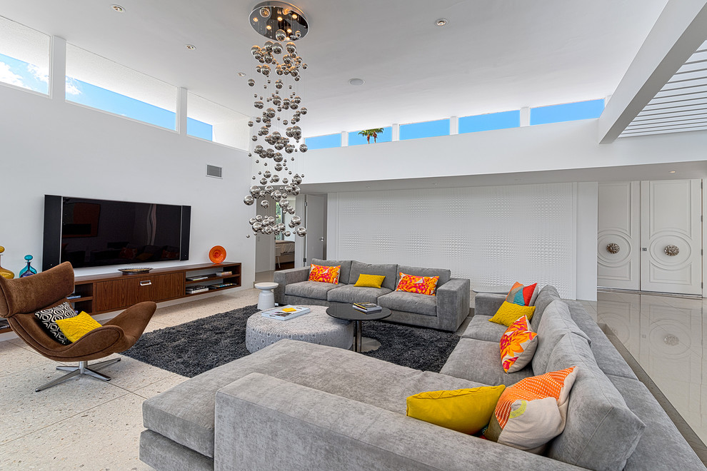 Photo of a midcentury open concept family room in Los Angeles with white walls, travertine floors and a wall-mounted tv.
