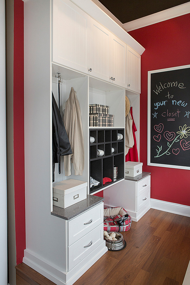 This is an example of a transitional mudroom in Raleigh with red walls, dark hardwood floors and brown floor.