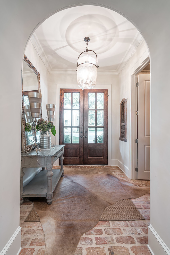 Photo of a foyer in Other with white walls, brick floors, a double front door and a medium wood front door.