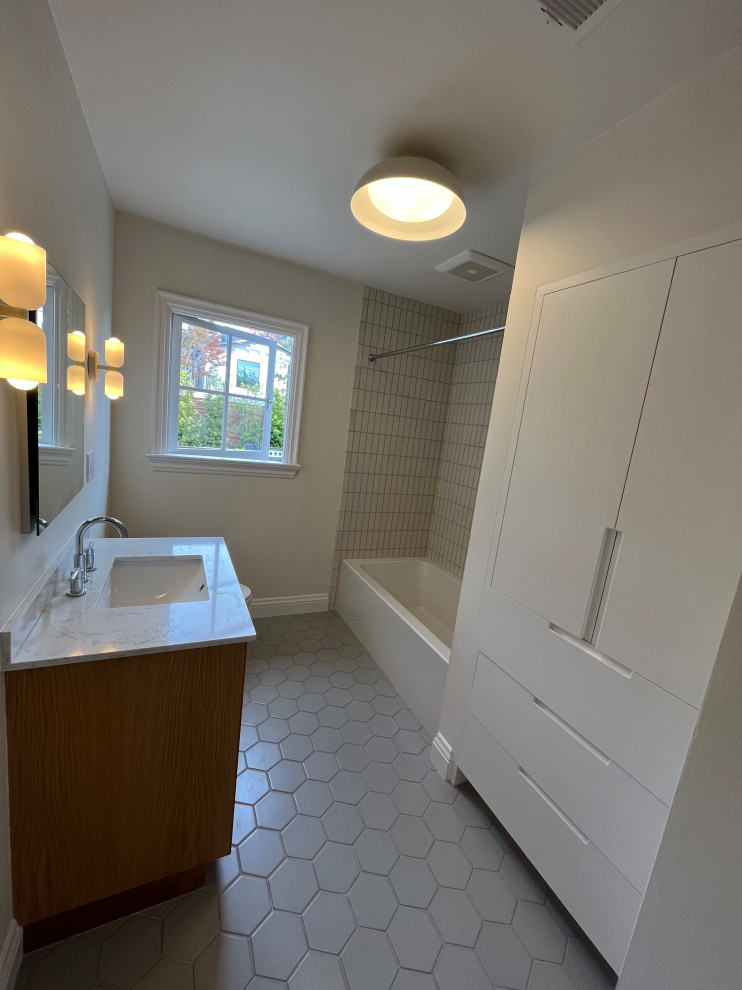 На фото: маленькая детская ванная комната в современном стиле с белой плиткой, керамической плиткой, полом из керамической плитки, серым полом, тумбой под одну раковину и встроенной тумбой для на участке и в саду