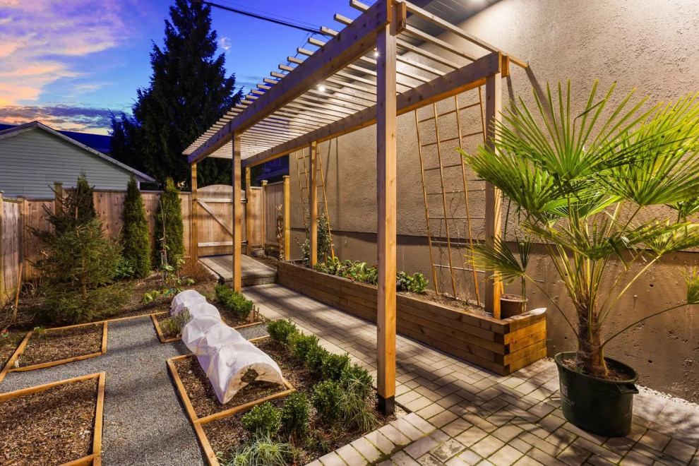 Design ideas for a large transitional backyard patio in Vancouver with a vegetable garden, brick pavers and a pergola.