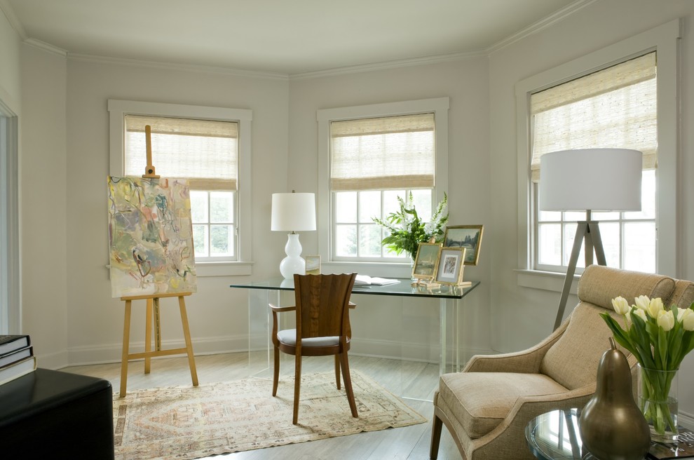 Traditional home office in DC Metro with beige walls, light hardwood floors and a freestanding desk.