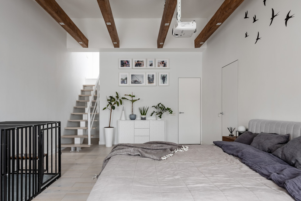 Aménagement d'une grande chambre parentale blanche et bois scandinave avec un mur blanc, parquet clair, un sol beige et poutres apparentes.