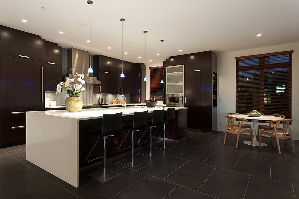 Contemporary eat-in kitchen in Vancouver with flat-panel cabinets, dark wood cabinets, grey splashback and panelled appliances.