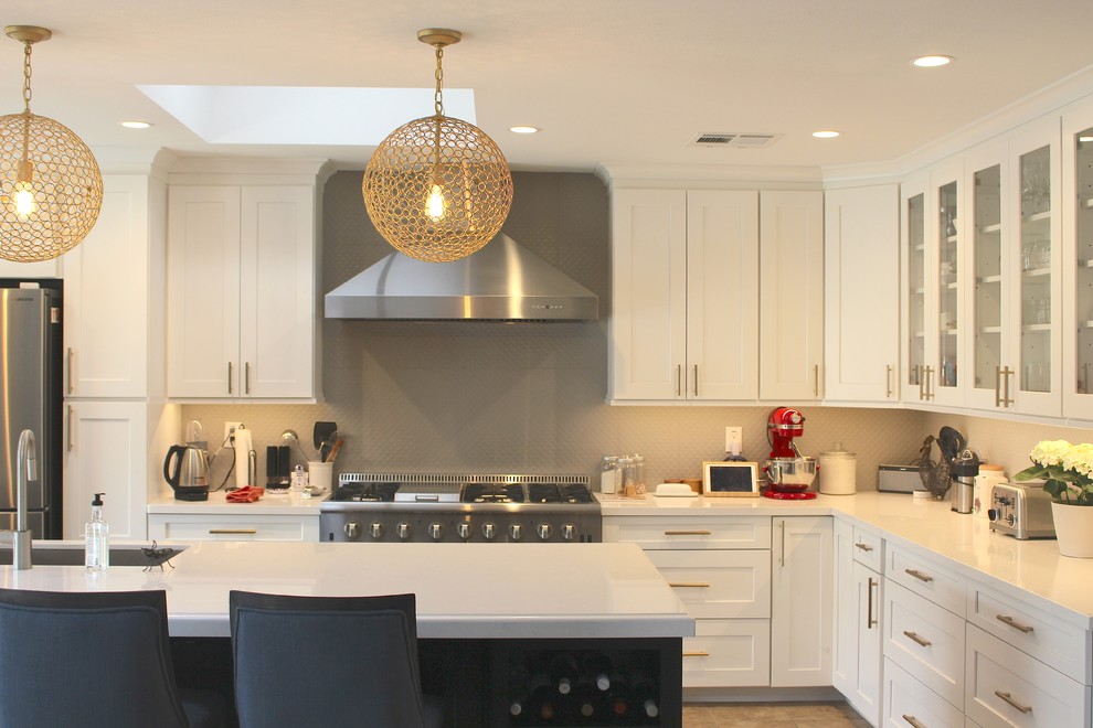 Open concept kitchen - large transitional l-shaped ceramic tile and beige floor open concept kitchen idea in Phoenix with an undermount sink, shaker cabinets, white cabinets, quartzite countertops, gray backsplash, stainless steel appliances and an island