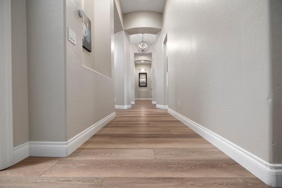 Hallway - large modern vinyl floor and brown floor hallway idea in Phoenix with gray walls