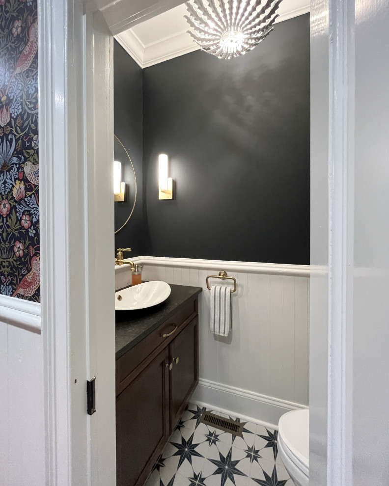 Cette image montre un petit WC et toilettes rustique en bois foncé avec un placard avec porte à panneau encastré, WC séparés, un mur bleu, une vasque, un plan de toilette en granite, un sol multicolore, un plan de toilette noir et meuble-lavabo sur pied.