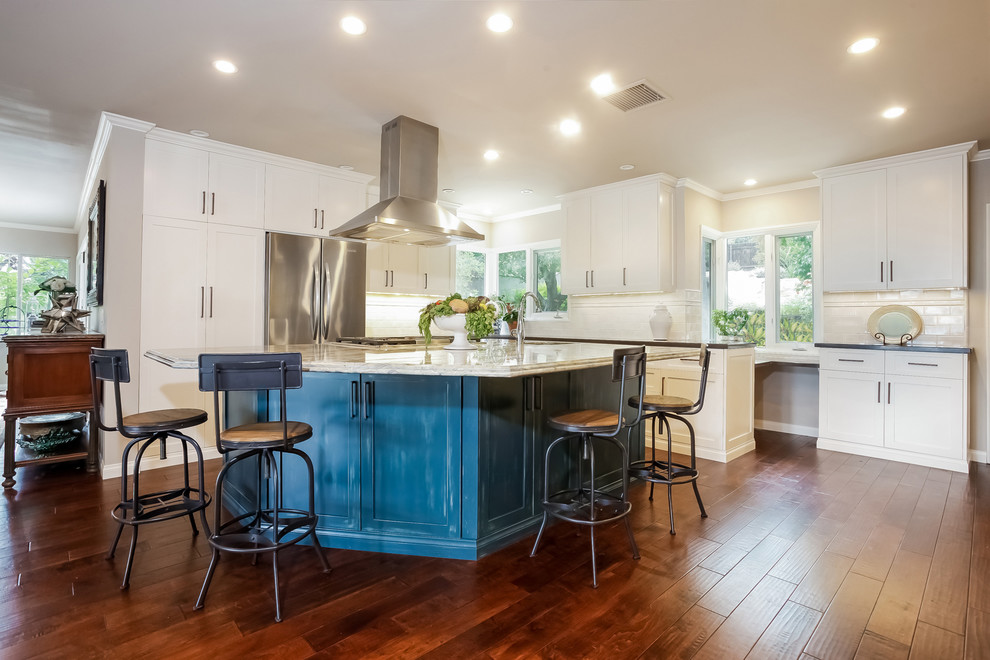 Inspiration for a large transitional u-shaped open plan kitchen in Los Angeles with with island, shaker cabinets, white cabinets, white splashback, subway tile splashback, stainless steel appliances, medium hardwood floors, a double-bowl sink and quartzite benchtops.