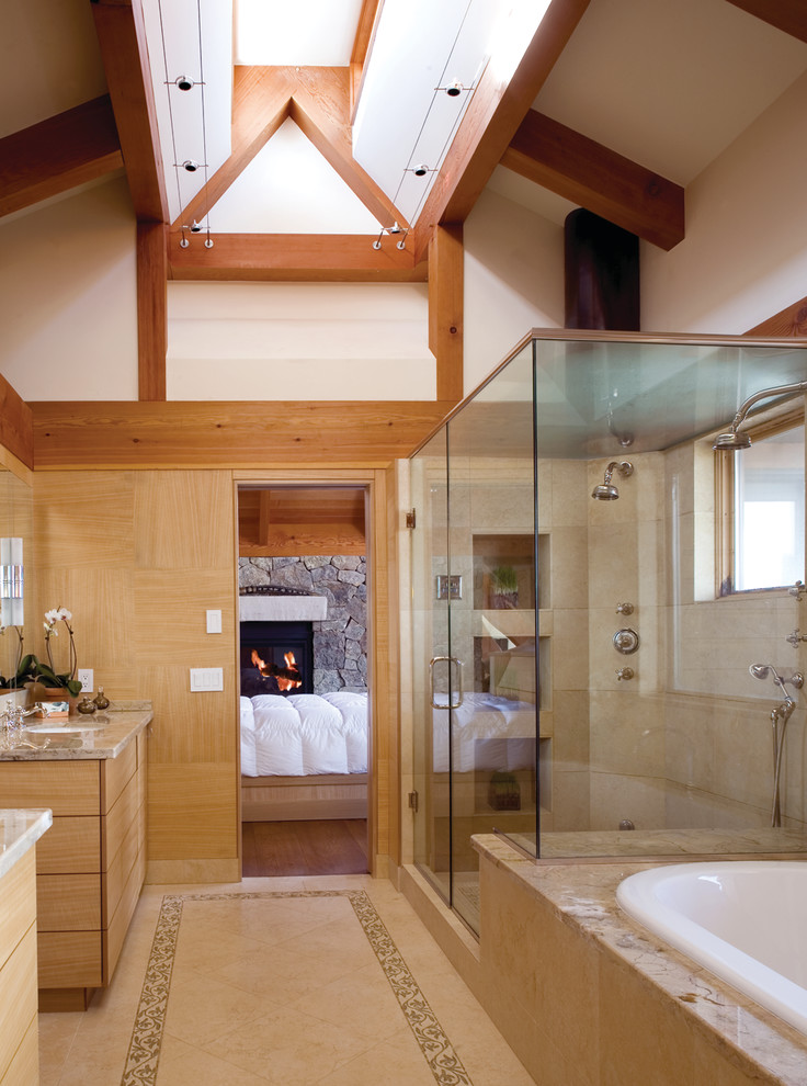 This is an example of a country master bathroom in Denver with flat-panel cabinets, light wood cabinets, a drop-in tub, a corner shower, beige tile, white walls, beige floor, a hinged shower door and brown benchtops.