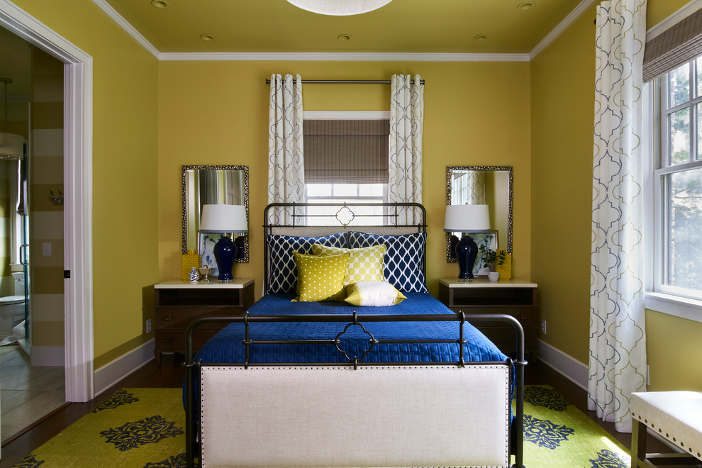 This is an example of a transitional guest bedroom in Philadelphia with yellow walls, dark hardwood floors and brown floor.
