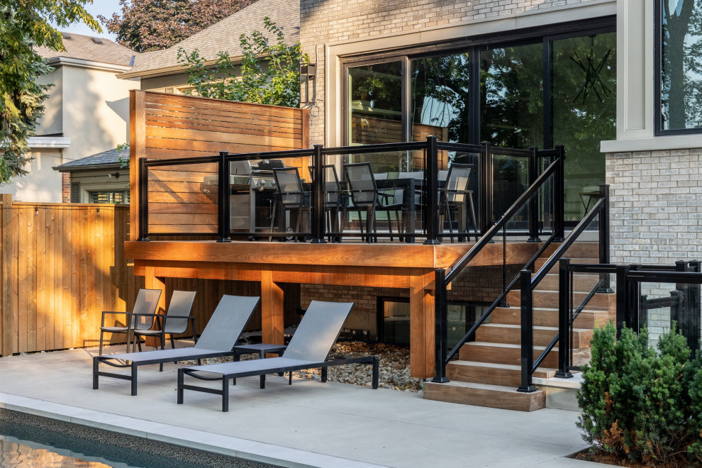 Imagen de piscina tradicional de tamaño medio rectangular en patio trasero con paisajismo de piscina y losas de hormigón