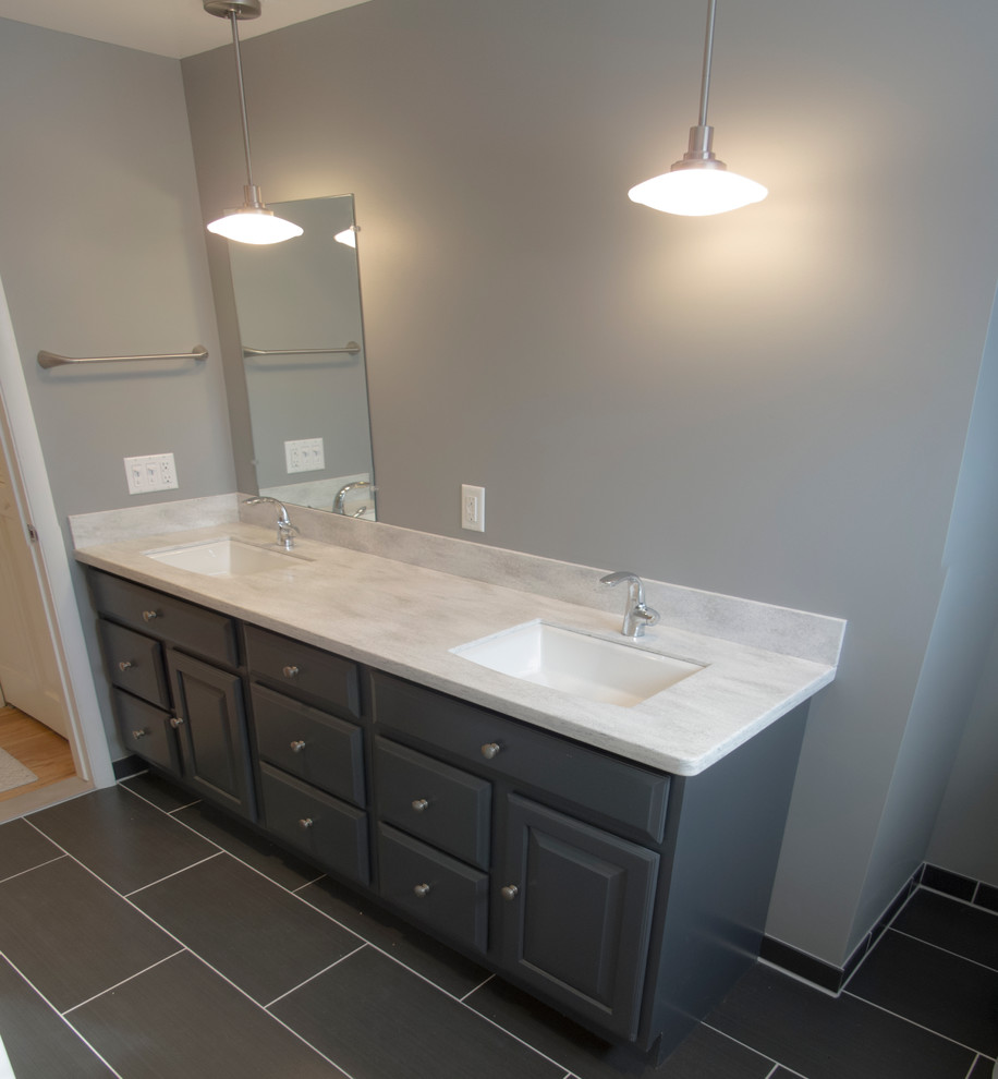 Design ideas for a small contemporary 3/4 bathroom in Detroit with an undermount sink, raised-panel cabinets, grey cabinets, laminate benchtops, an alcove tub, a shower/bathtub combo, a two-piece toilet, gray tile, porcelain tile, grey walls and porcelain floors.
