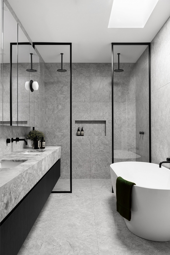 Design ideas for a mid-sized contemporary master bathroom in Melbourne with grey cabinets, a freestanding tub, a double shower, a one-piece toilet, gray tile, stone tile, grey walls, marble floors, an undermount sink, marble benchtops, grey floor, an open shower and grey benchtops.