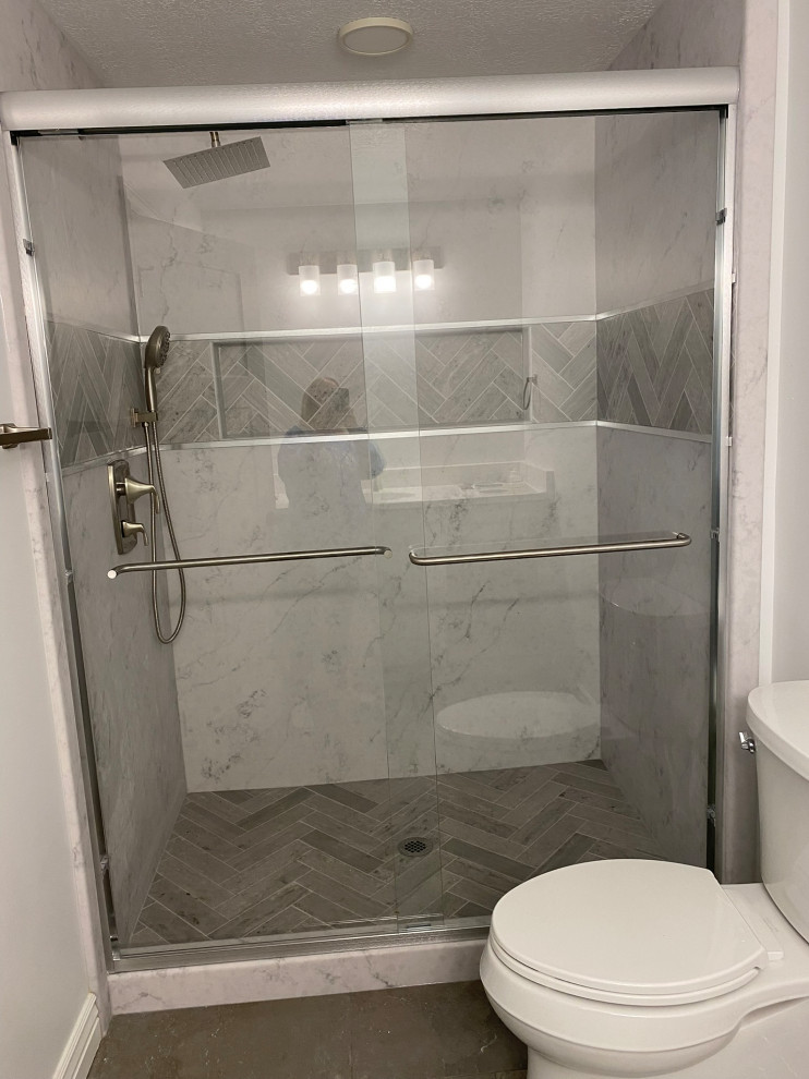 Basement bathroom solid surface shower after sliding shower glass installation.