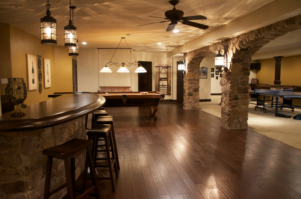 Large traditional look-out basement in Philadelphia with beige walls, dark hardwood floors and multi-coloured floor.