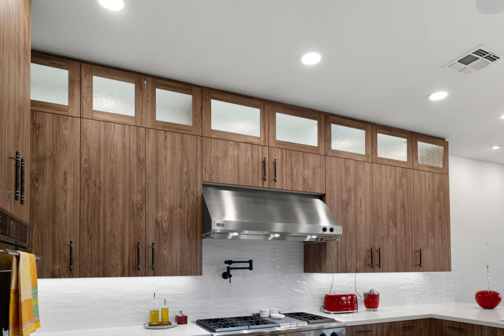 Inspiration for a rustic l-shaped slate floor and beige floor enclosed kitchen remodel with a single-bowl sink, flat-panel cabinets, medium tone wood cabinets, quartzite countertops, white backsplash, glass sheet backsplash, stainless steel appliances, a peninsula and white countertops