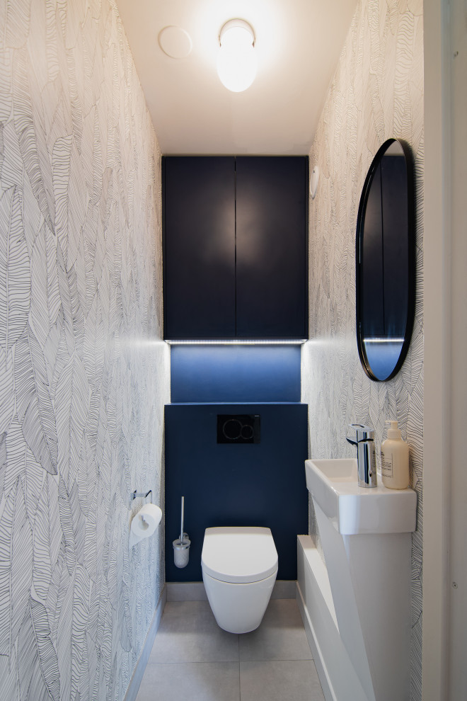 Idee per un bagno di servizio minimalista di medie dimensioni con WC sospeso, pareti grigie, pavimento in cementine, lavabo sospeso, top in legno, top blu, mobile bagno sospeso e carta da parati