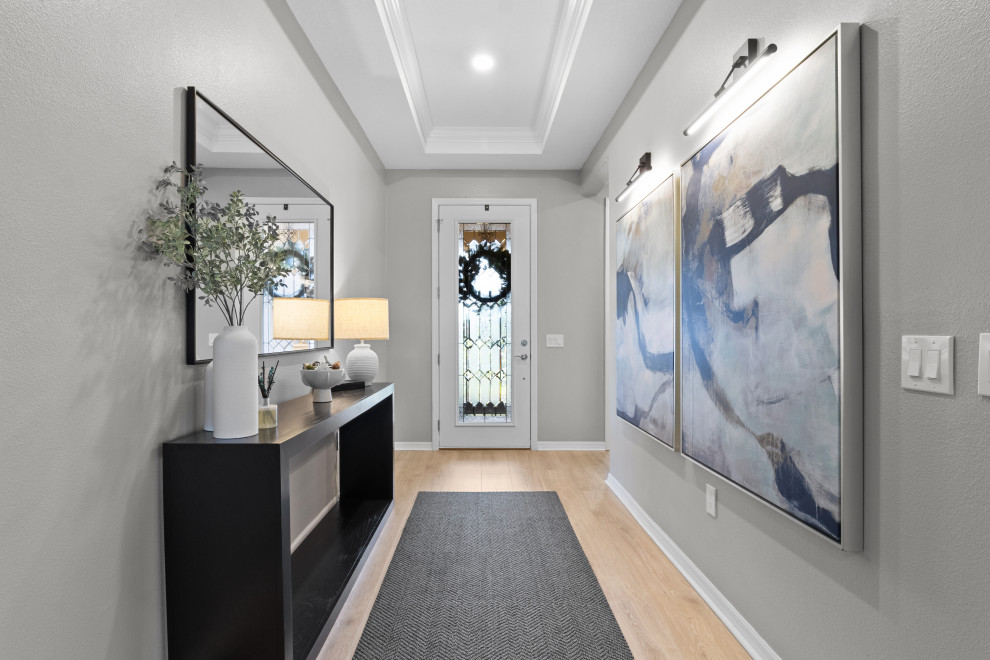 Photo of a large contemporary entry hall in Orlando with grey walls, a single front door and a white front door.