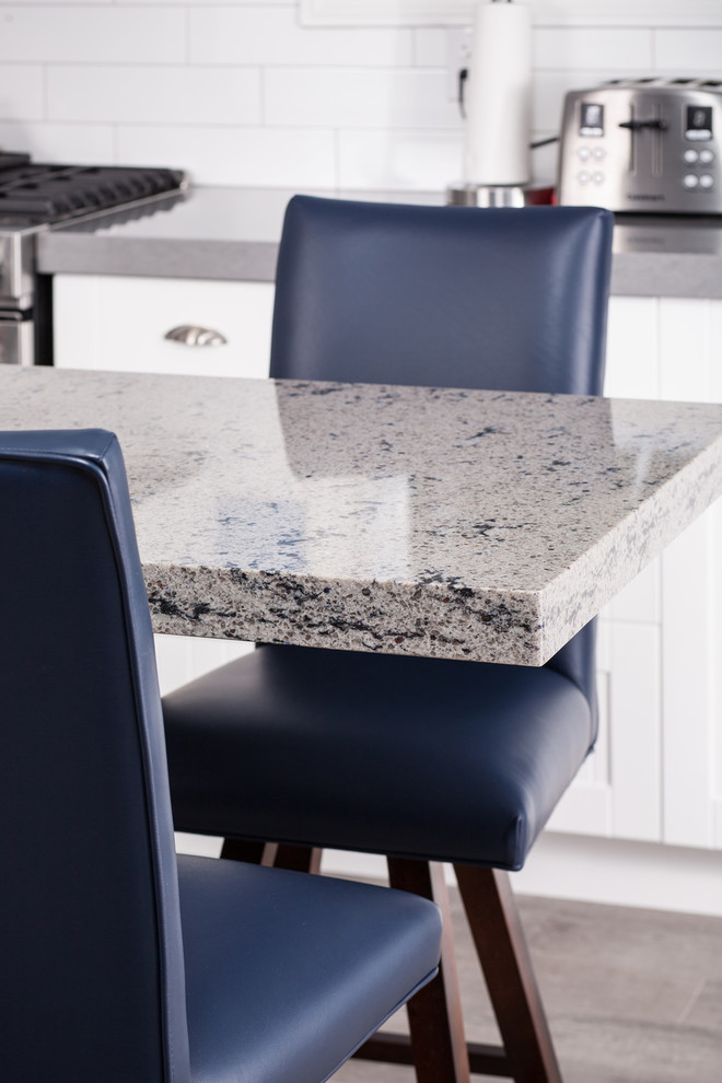 Mid-sized transitional l-shaped light wood floor enclosed kitchen photo with an undermount sink, beaded inset cabinets, white cabinets, granite countertops, white backsplash, ceramic backsplash, stainless steel appliances and an island