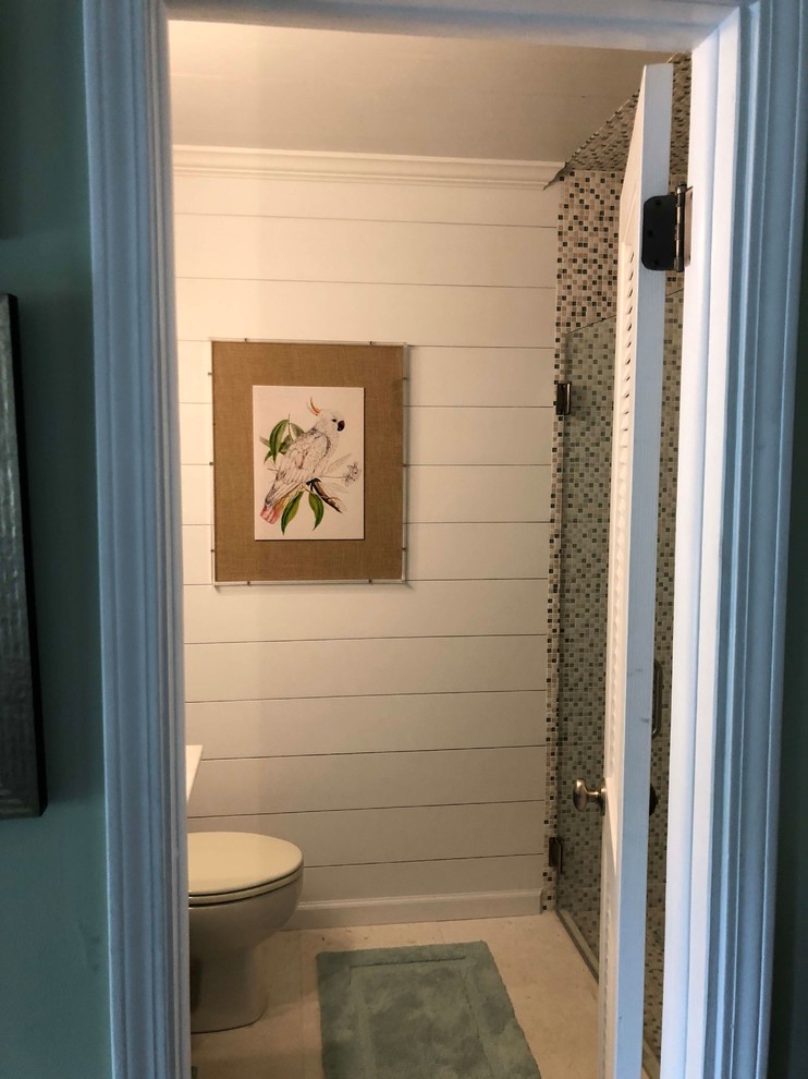 Design ideas for a mid-sized beach style wet room bathroom in Jacksonville with furniture-like cabinets, turquoise cabinets, a two-piece toilet, multi-coloured tile, mosaic tile, white walls, travertine floors, an undermount sink, granite benchtops, beige floor, a hinged shower door and white benchtops.